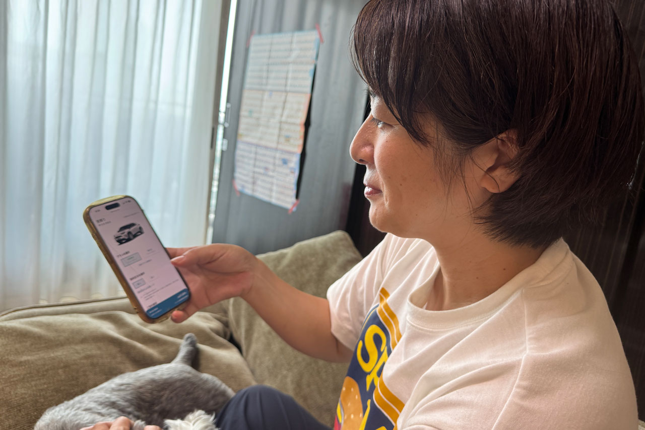 自宅で犬をなでながらKINTOを選んでいる様子