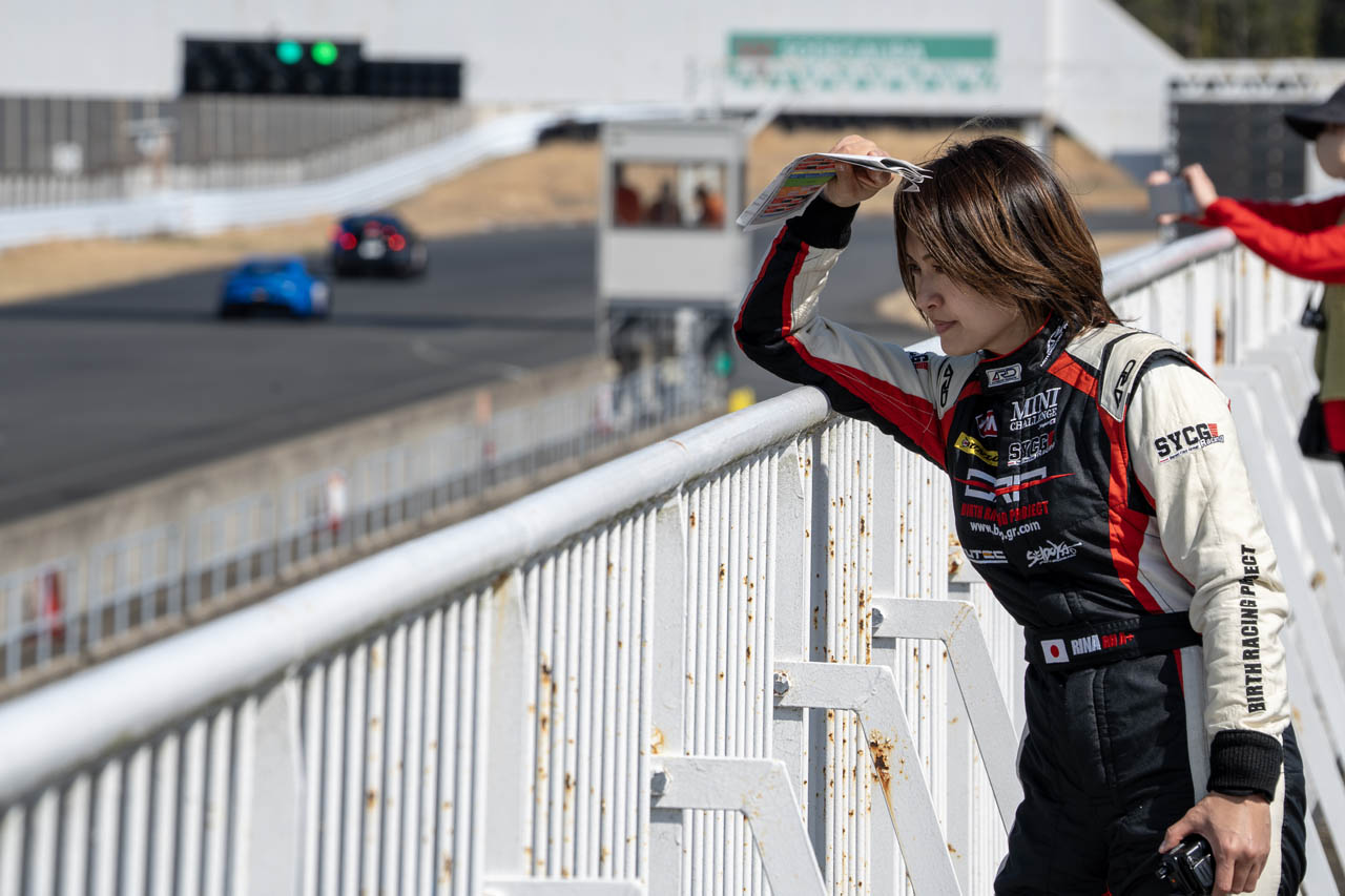 パドック上のスタンドから各車の走行を見ながら無線でアドバイスを送るいとうりなさん