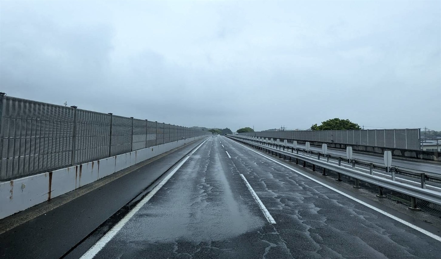 雨で濡れた高速道路の路面と直線道路風景（悪天候・交通イメージ）