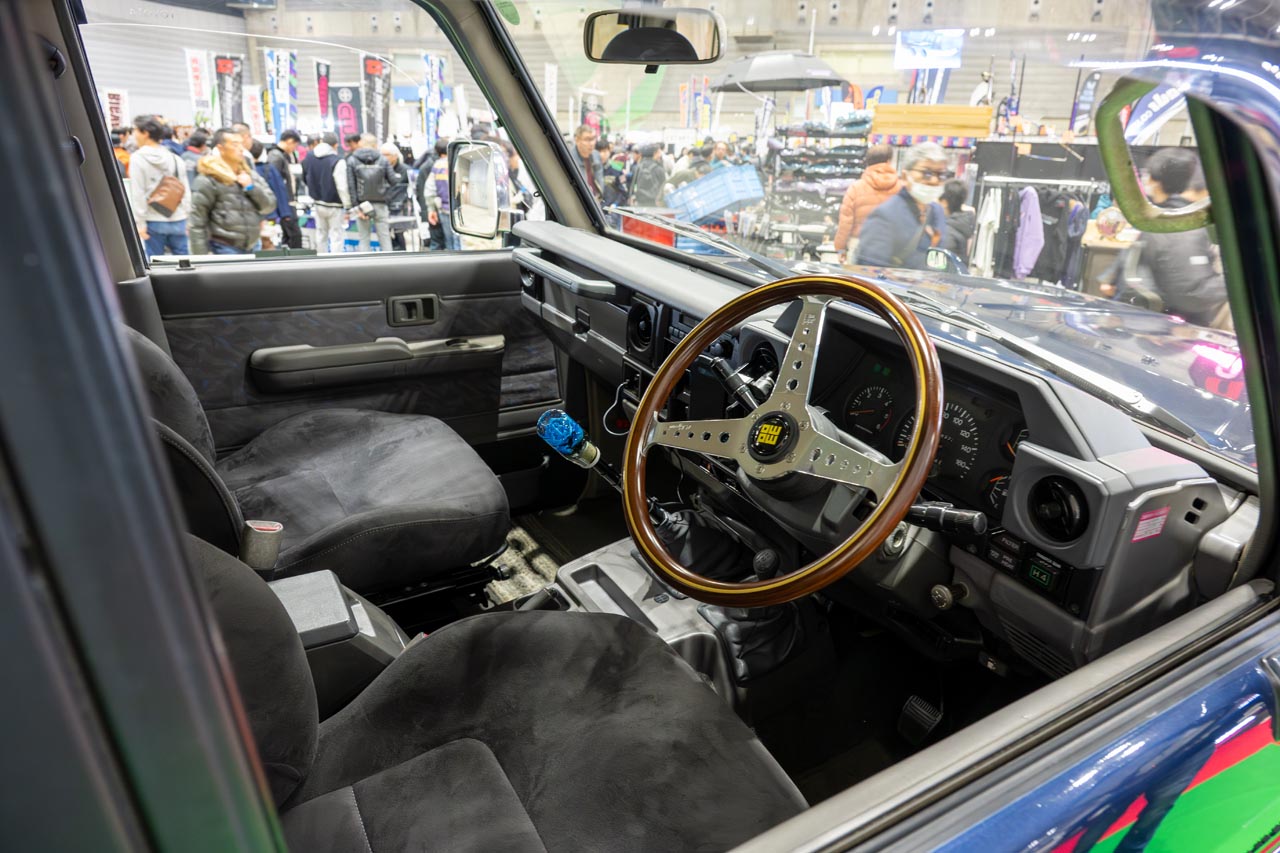 ウインドウスクリーンが切り立った本格クロカンならではのインテリア。ステアリングはウッド素材のMOMO製に交換されています。トランスミッションは副変速機付の5MT