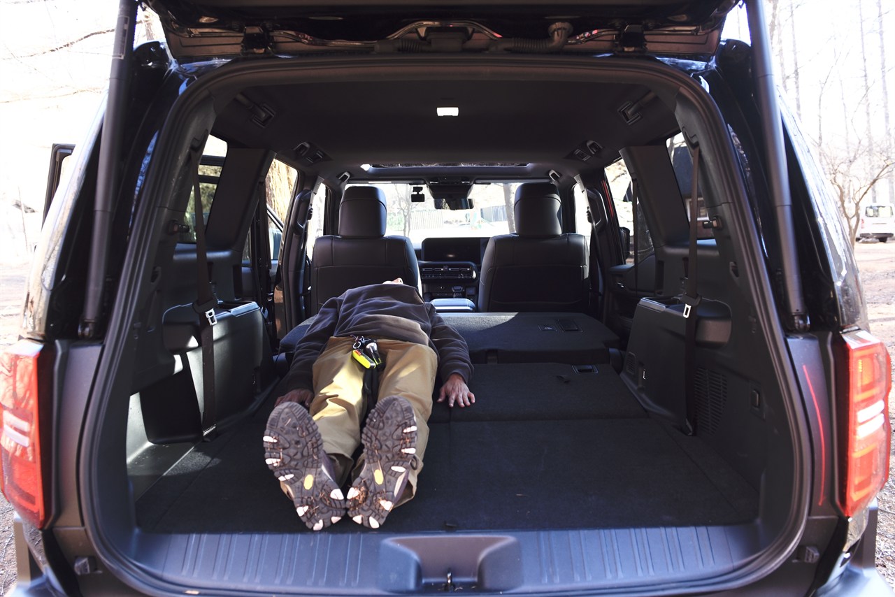 車中泊女性が寝転ぶ写真